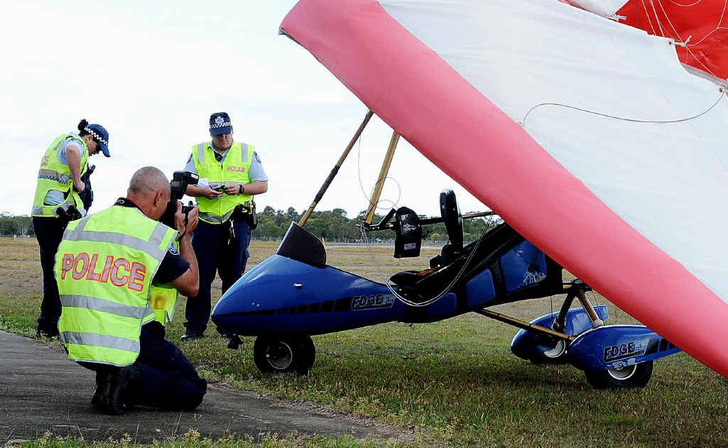 Police attend the scene of a microlight crash at the Hervey Bay airport yesterday morning. Police attend the scene of a microlight crash at the Hervey Bay airport yesterday morning.